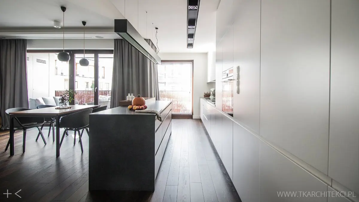Biała kuchnia otwarta na salon i jadalnię | proj. TK Architekci