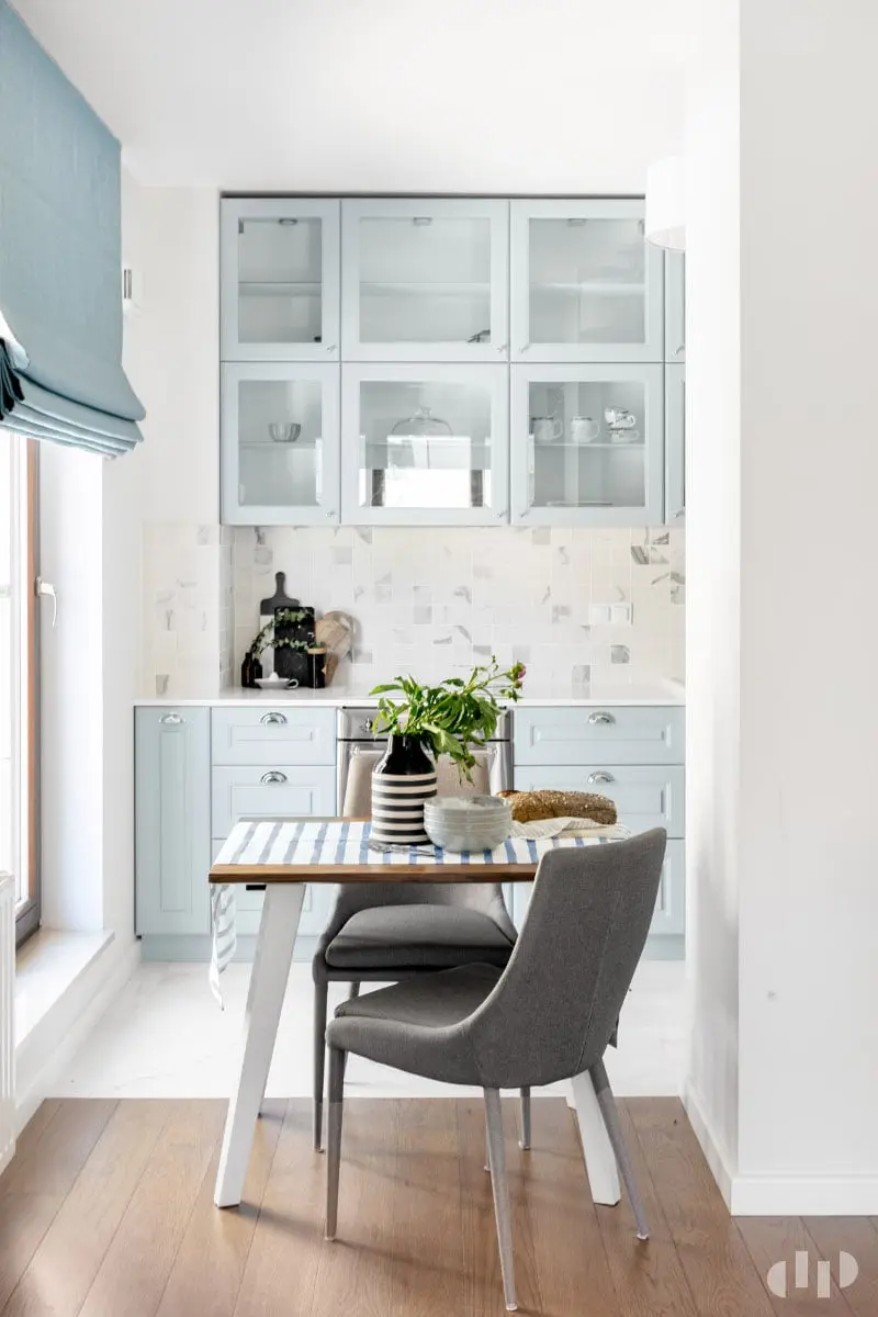 Mała kuchnia z błękitnymi meblami i marmurowymi płytkami nad blatem | proj. Dziurdzia Projekt
