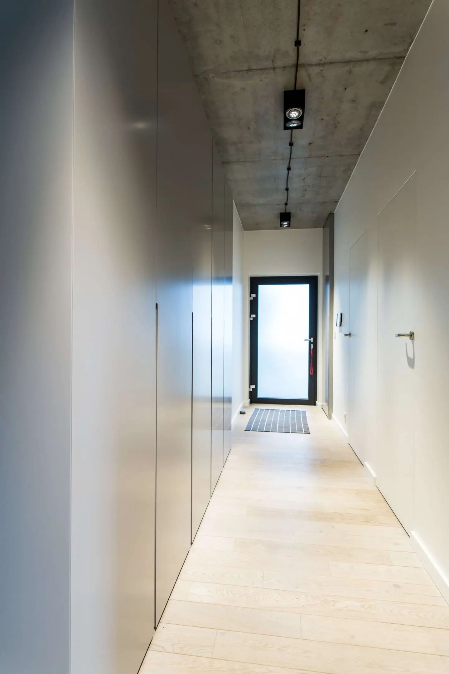 Minimalistyczny hol z industrialnymi elementami | proj. NOWW Studio