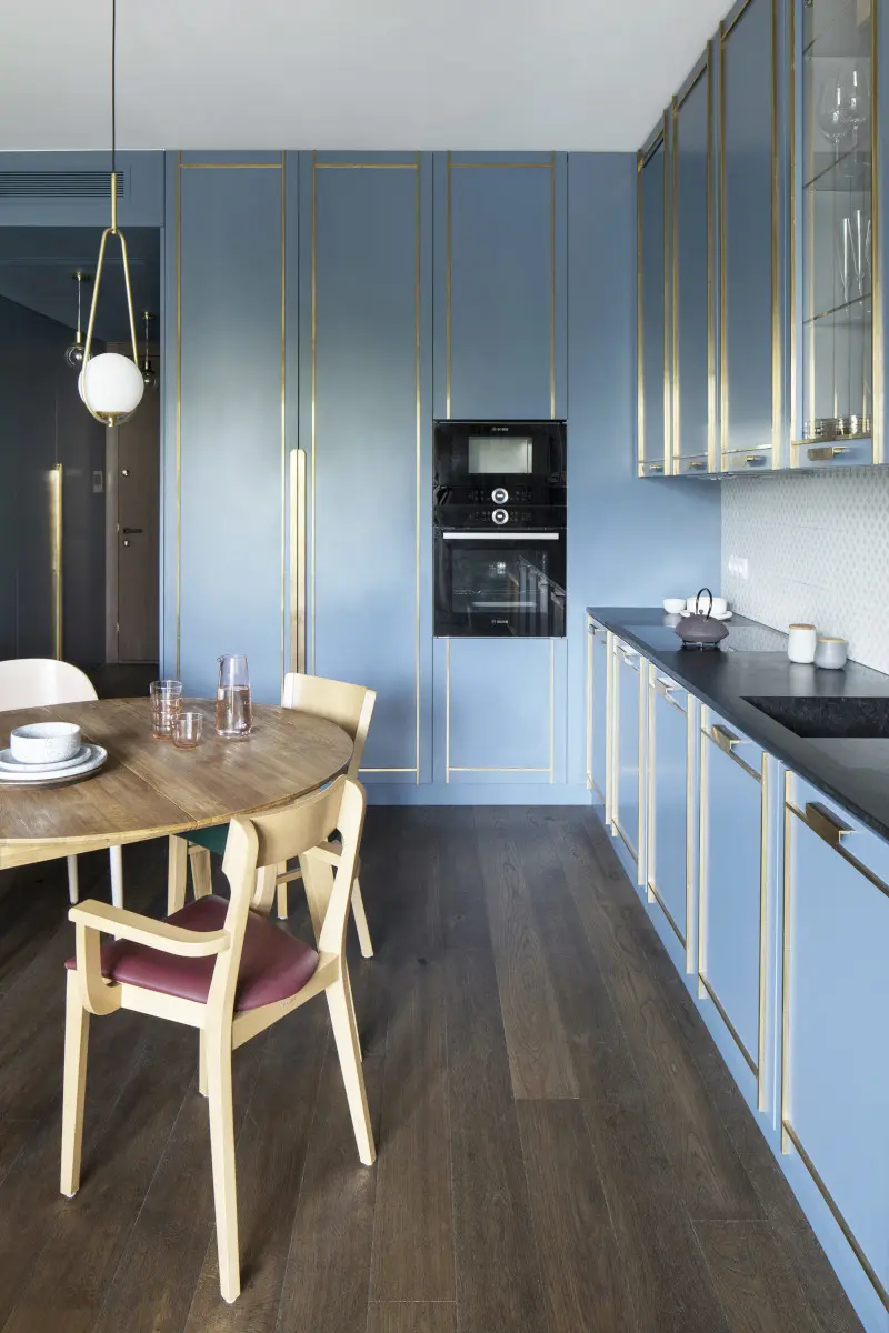 Niebieska kuchnia ocieplona drewnem | proj. Kando Architects