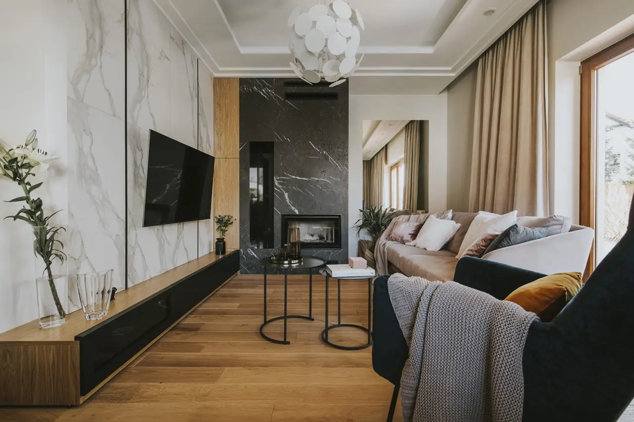 Wielkoformatowe płytki na ścianie w salonie (proj. Finchstudio)