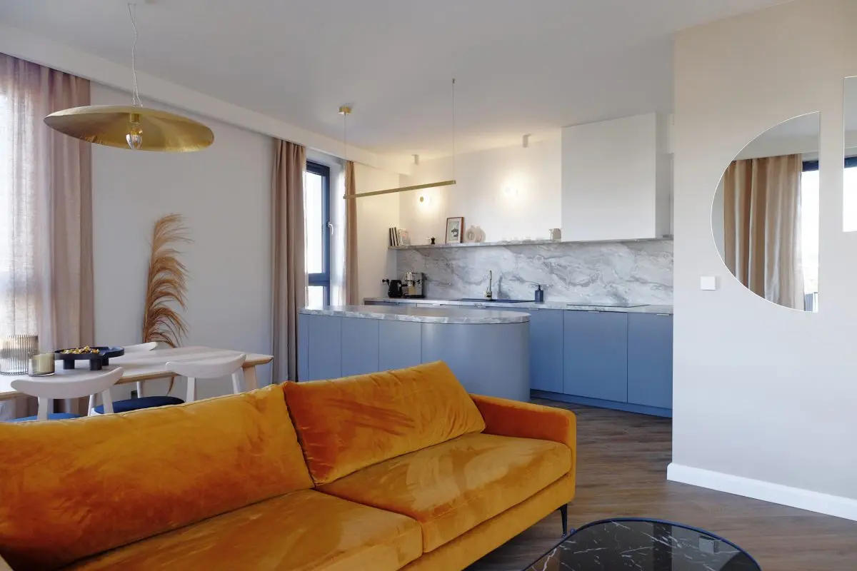 Meble kuchenne w kolorze Faded Denim zestawione z welurową sofą w odcieniu Orange Peel | Projekt Małgorzata Caban Architektura Wnętrz