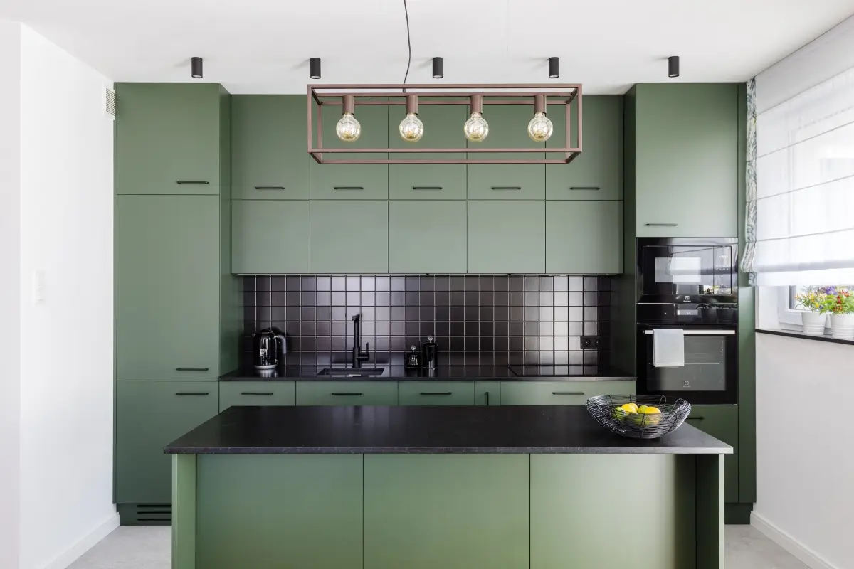 Oryginalna zielona kuchnia, dla której tłem są białe ściany. | Proj. AWAW; Fot: Michał Młynarczyk