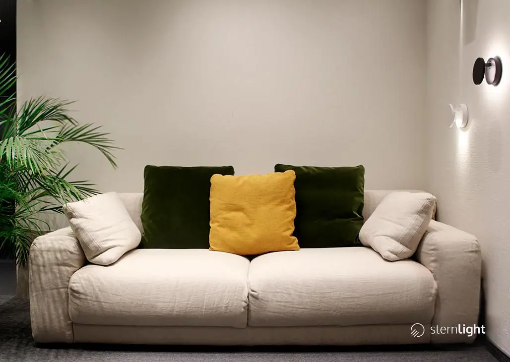 Zestaw kinkietów Halo przy sofie.