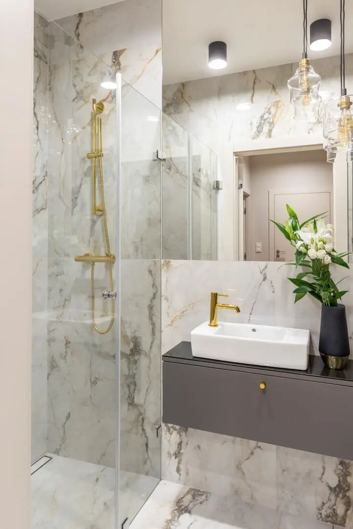 Marmurowa łazienka ze złotą armaturą | proj. Pomysłownia