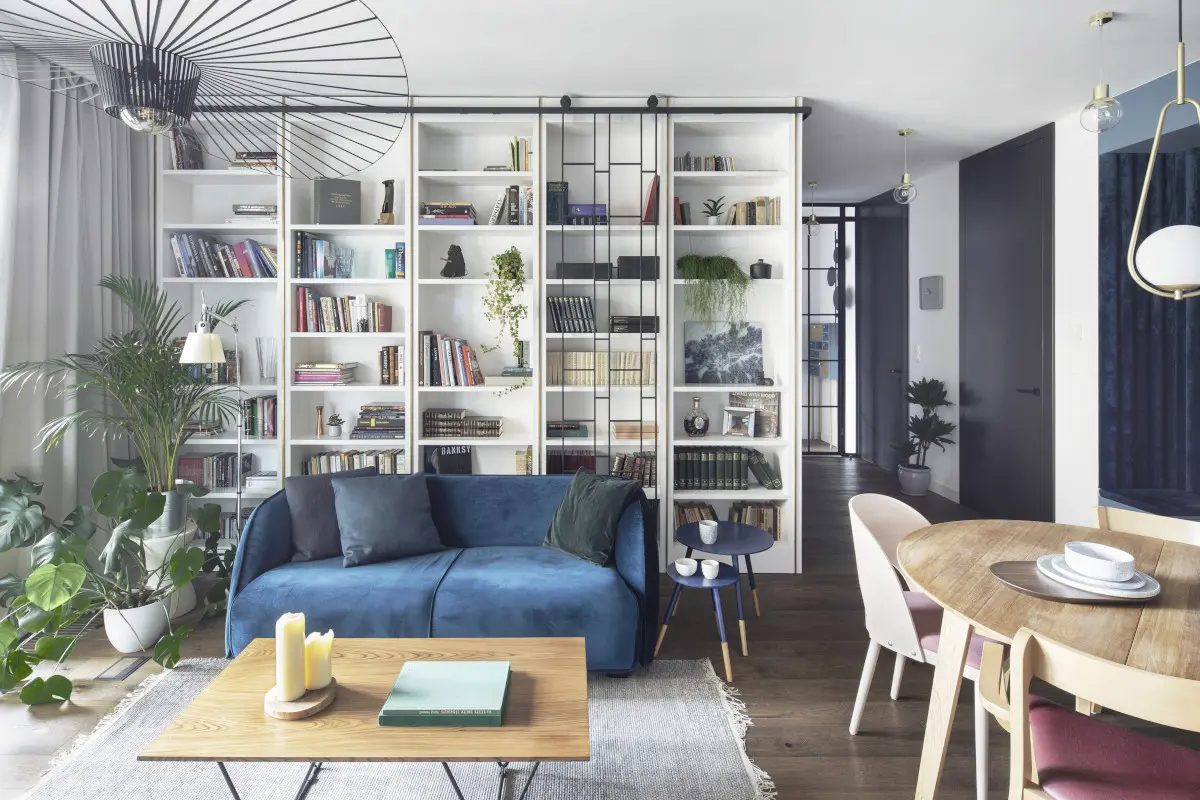 Stoliki na długich, cienkich nóżkach są komplementarne wobec sofy bez nóżek. | proj. Kando Architects